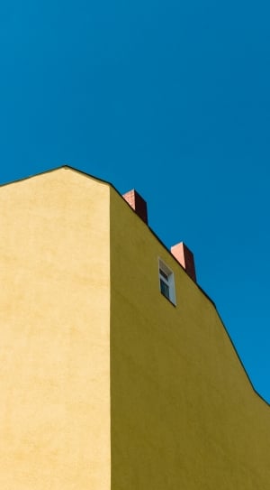 yellow and brown concrete building under blue sky thumbnail