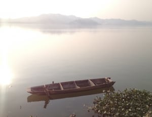 brown wooden boat on body of water during daytime thumbnail