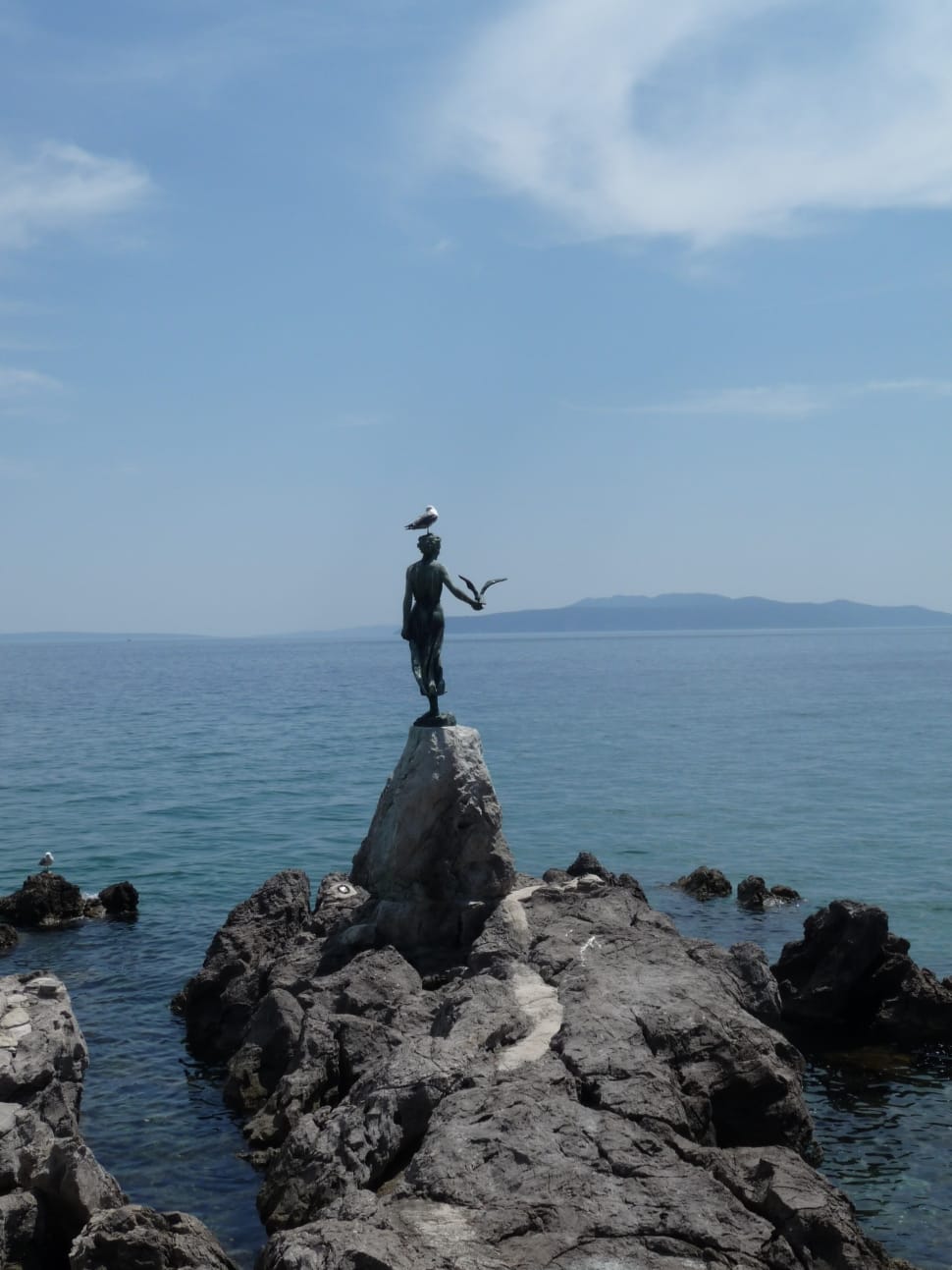 person standing beside a cliff stone statue preview