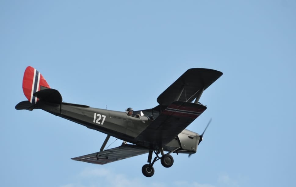 brown 127 plane flying during daytime under blue sky with white thin clouds preview