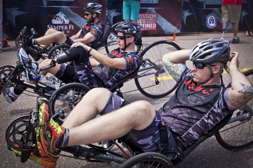 men wearing biking suit riding racing trike on road preview