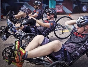 men wearing biking suit riding racing trike on road thumbnail