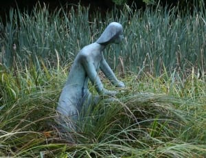 grey woman statue on green grass field during daytime thumbnail