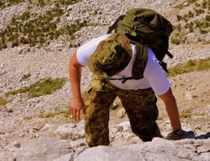 men's white shirt, green backpack, and camouflage cargo pants thumbnail