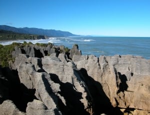 brown rock formations near sea thumbnail