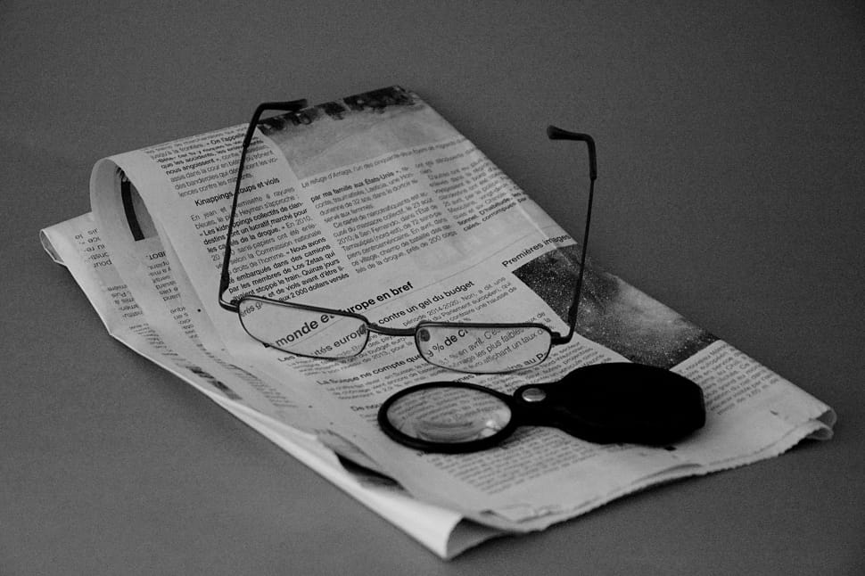 black framed eyeglasses and newspaper preview