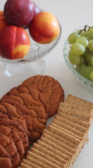 cookies and crackers on plate and red apple and green grape fruit thumbnail