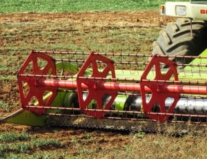 red and green Dominator cultivator on green field thumbnail