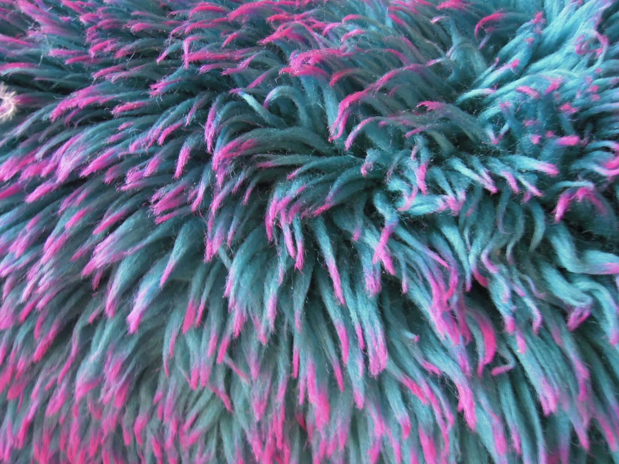 teal and pink furred textile