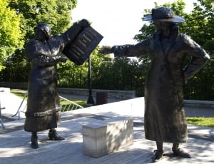 man carrying book  near woman statue thumbnail