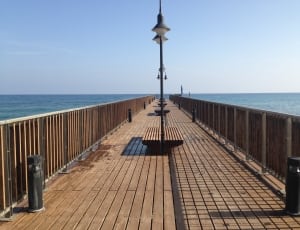 brown wooden pier under clear blue sky thumbnail