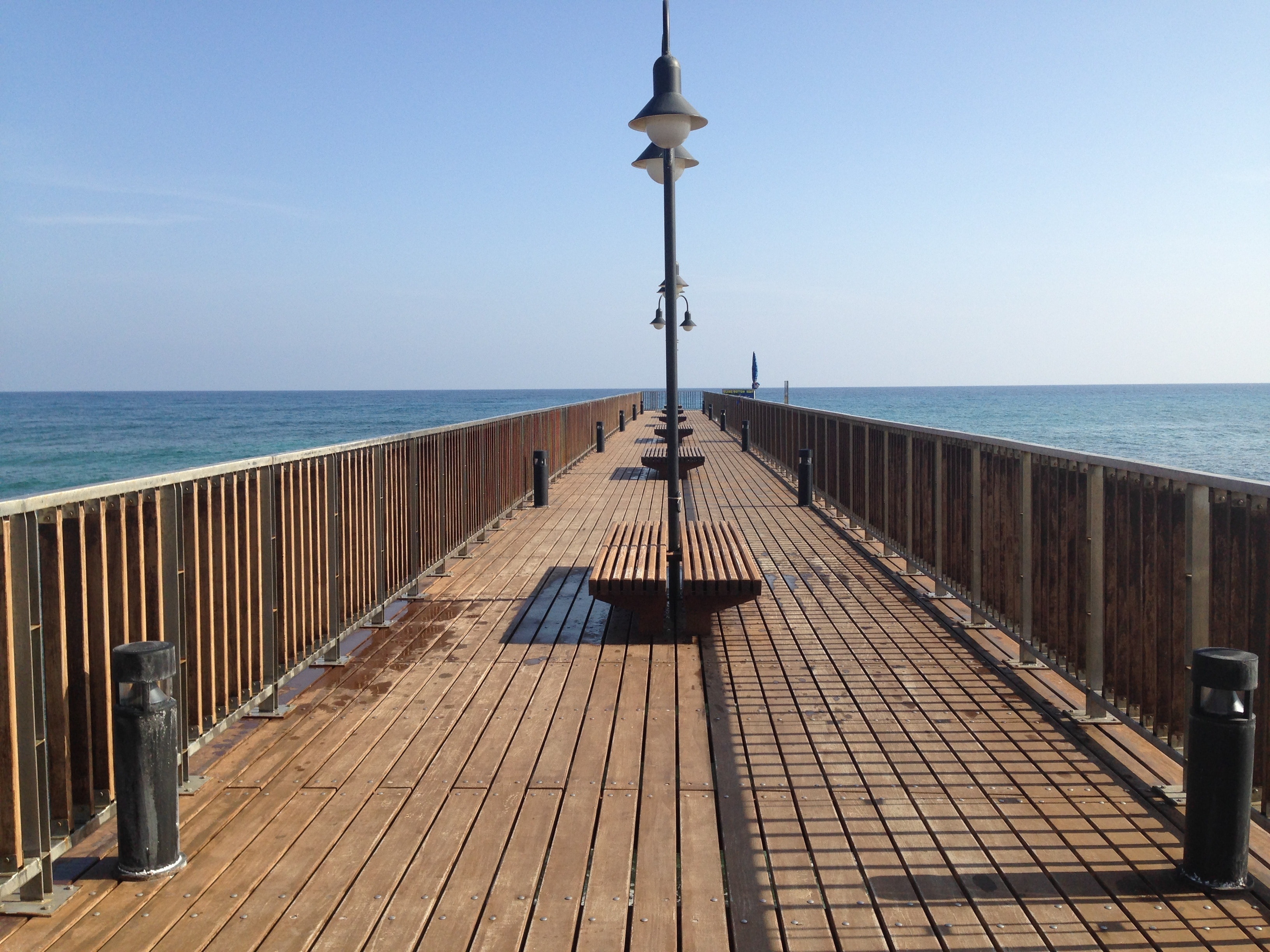 brown wooden pier under clear blue sky