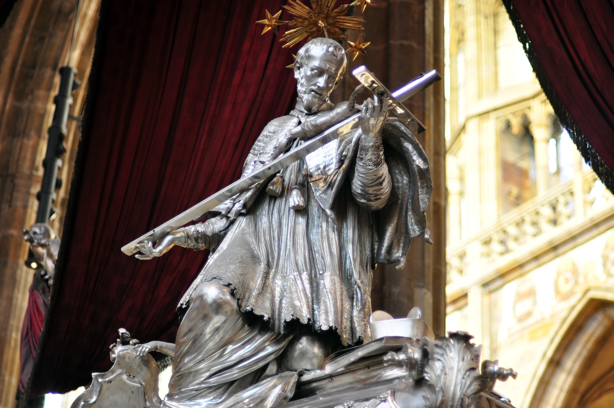 man carrying crucifix statue