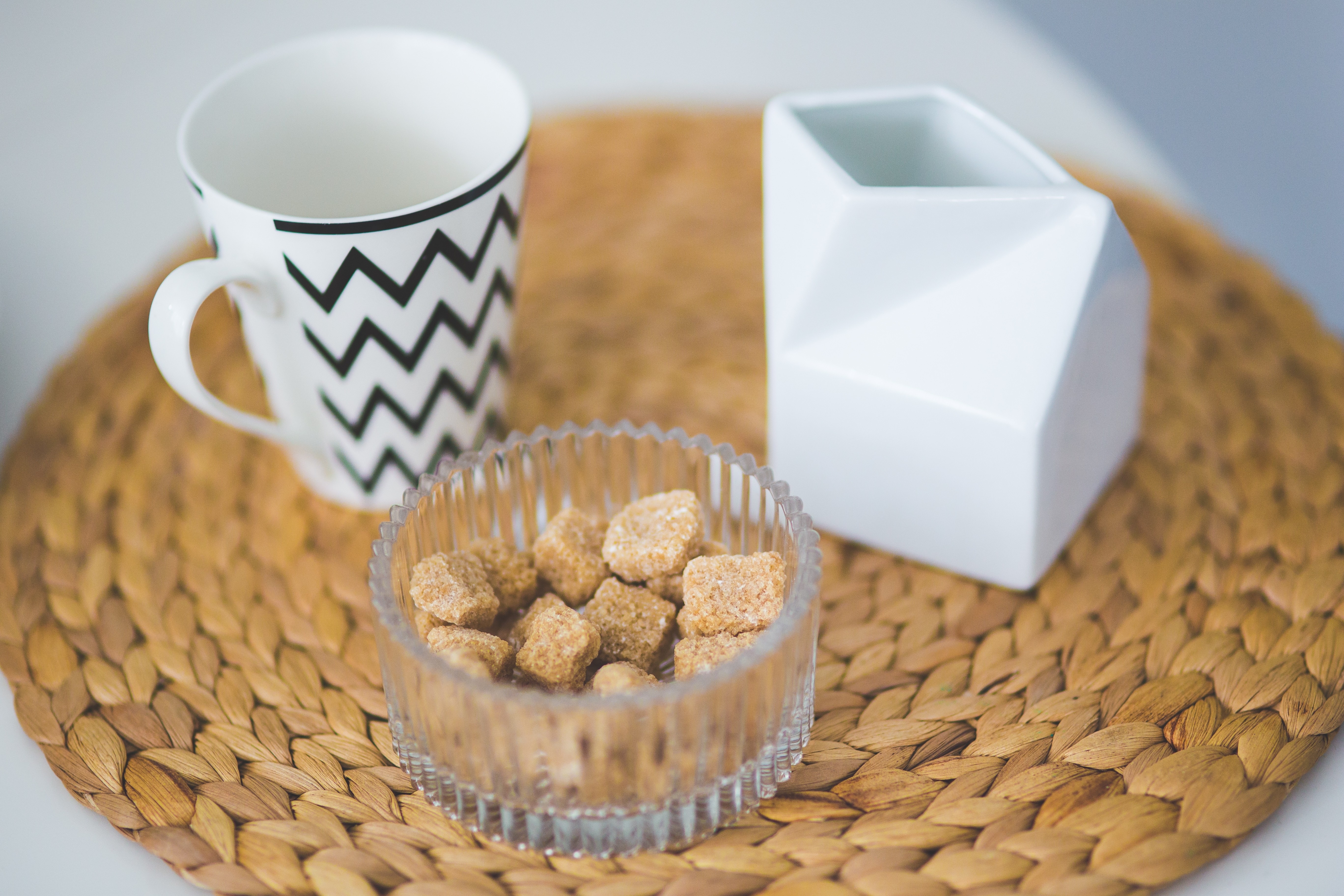 ceramic mug beside brown sugar cubes on the tray