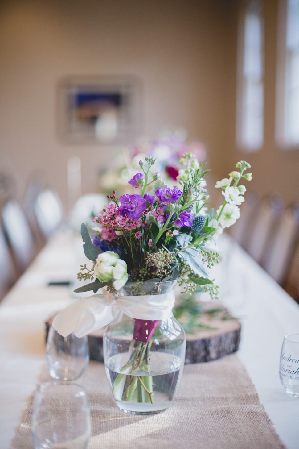purple, white, and pink petaled flowers centerpiece on beige and white covered table preview