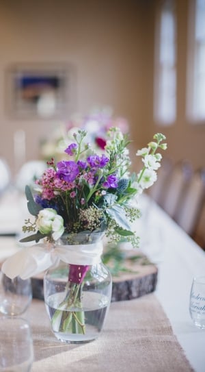 purple, white, and pink petaled flowers centerpiece on beige and white covered table thumbnail