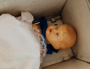 white textile on brown doll in box thumbnail