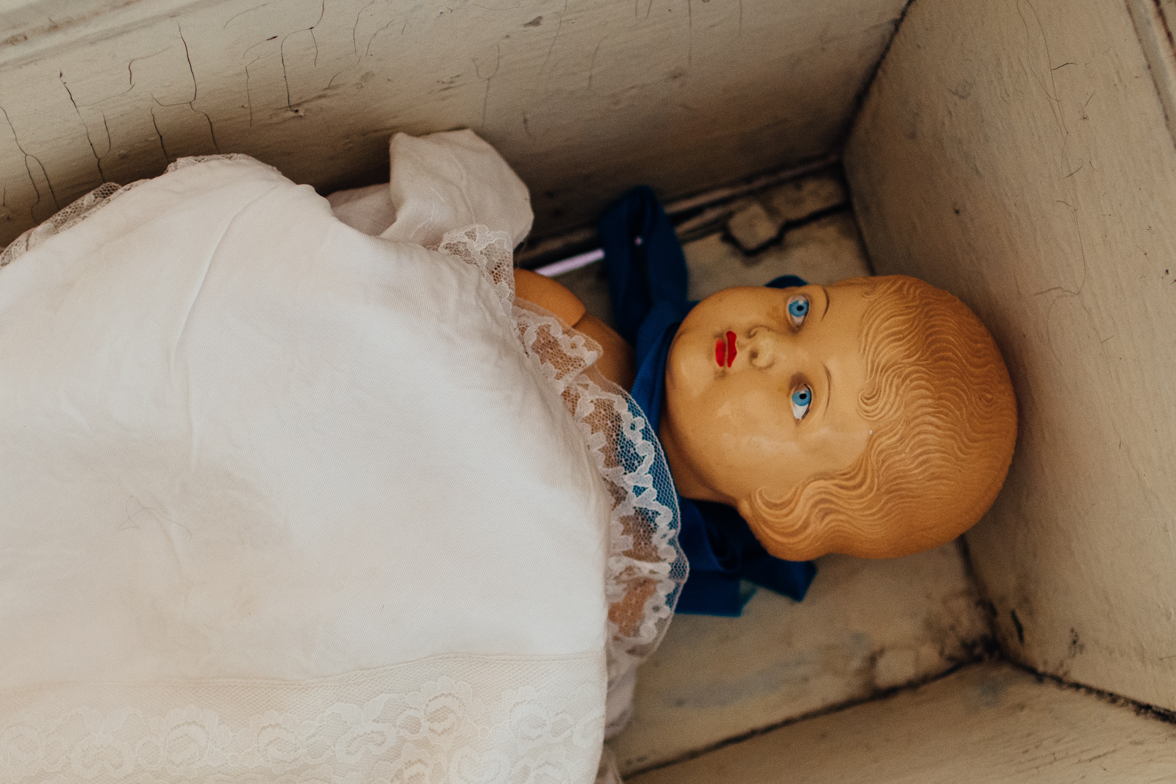 white textile on brown doll in box