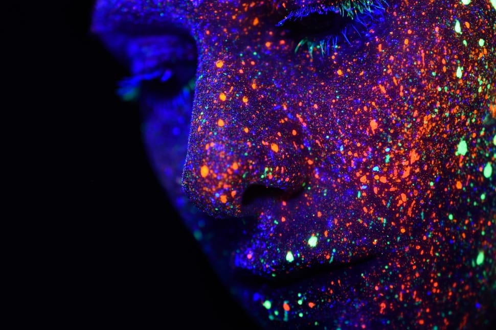 close up photography of person with uv reactive paint on face preview