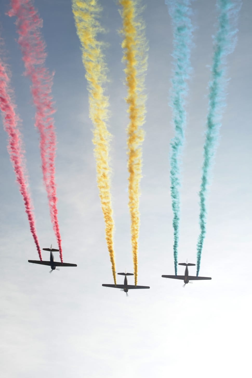 three airplanes discharging red yellow and blue smokes in air during daytime preview