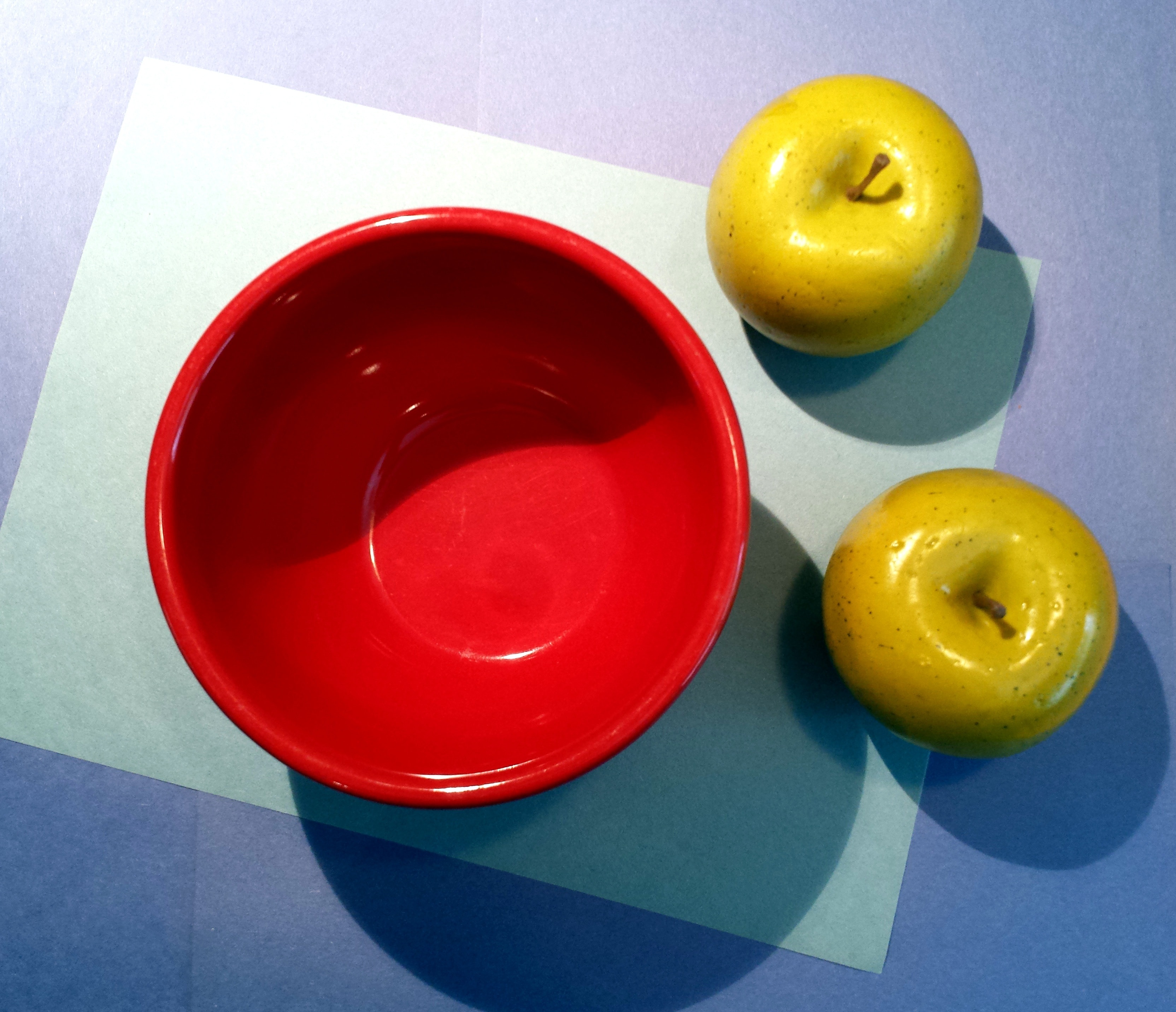 two green apple fruits near round red bowl