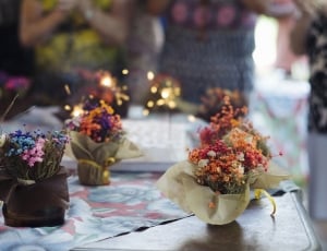 selective focus photography of 3 assorted flower table centerpieces thumbnail