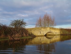 body of water and beige concrete arch bridge thumbnail