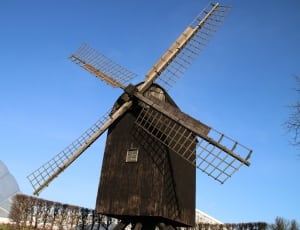 black wooden mill under blue sky thumbnail