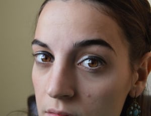 women's teal earring and black eyeliner thumbnail