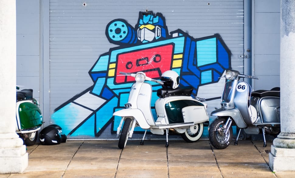 photo showing two white and gray motorcycle scooters preview