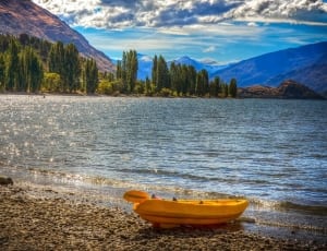 yellow kayak near body of water under blue sky during day time thumbnail