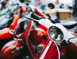 selective focus photography of red and white motor scooter thumbnail