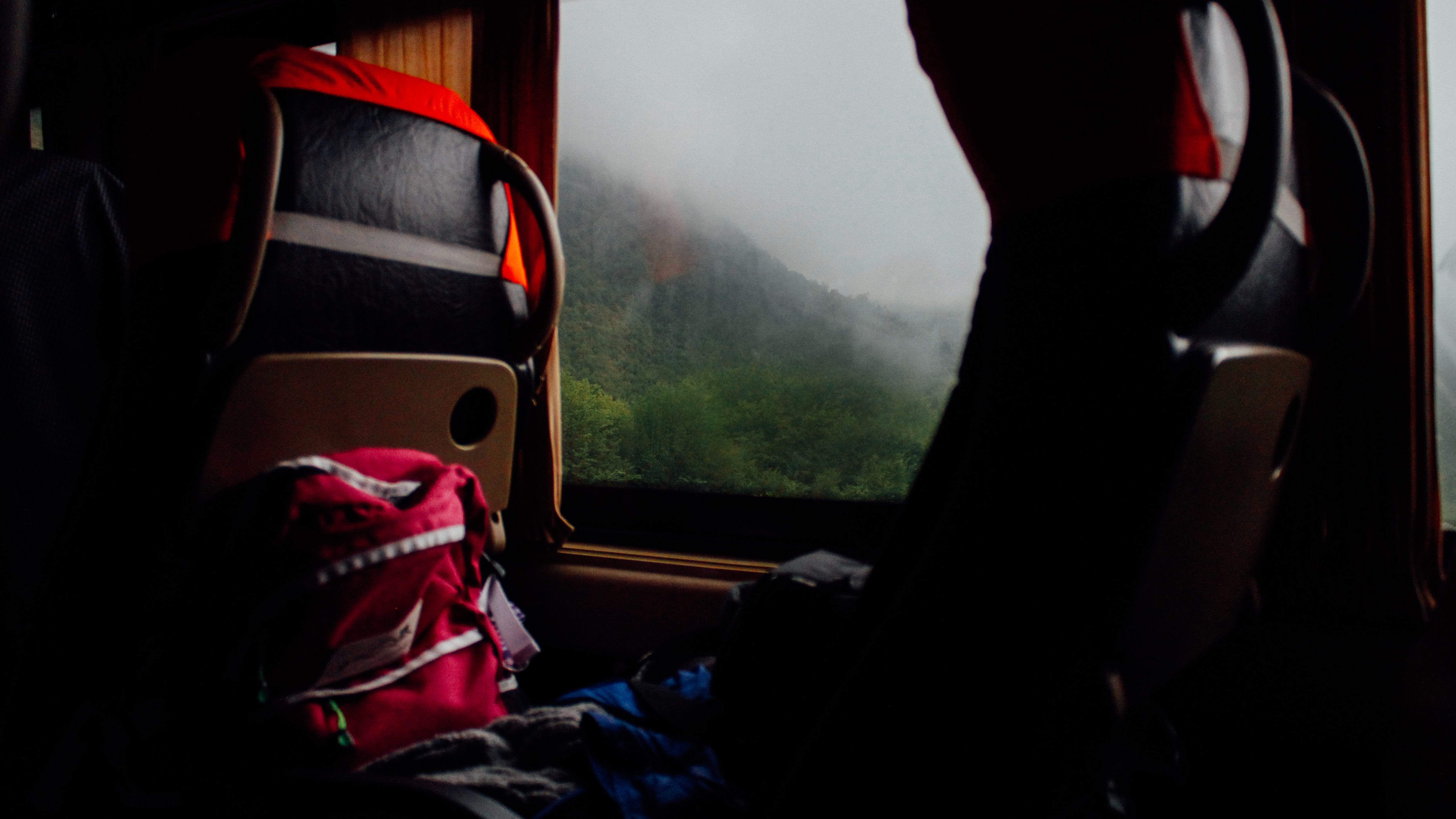 red backpack and brown wooden chair