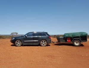 Blue SUV with trailer under blue sky during daytime thumbnail