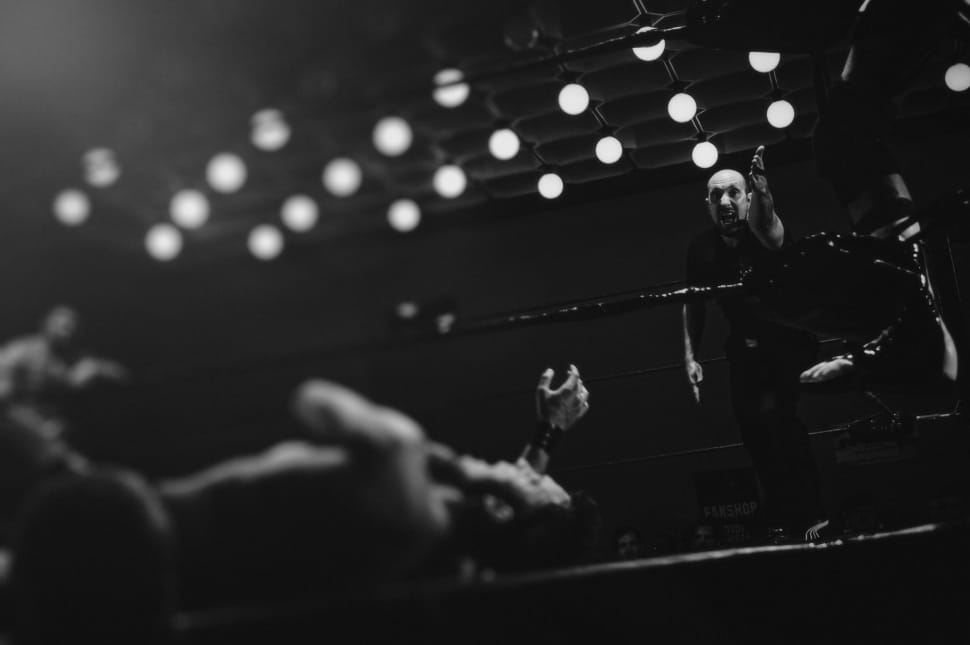 grayscale photo of wresler lying on the ring preview