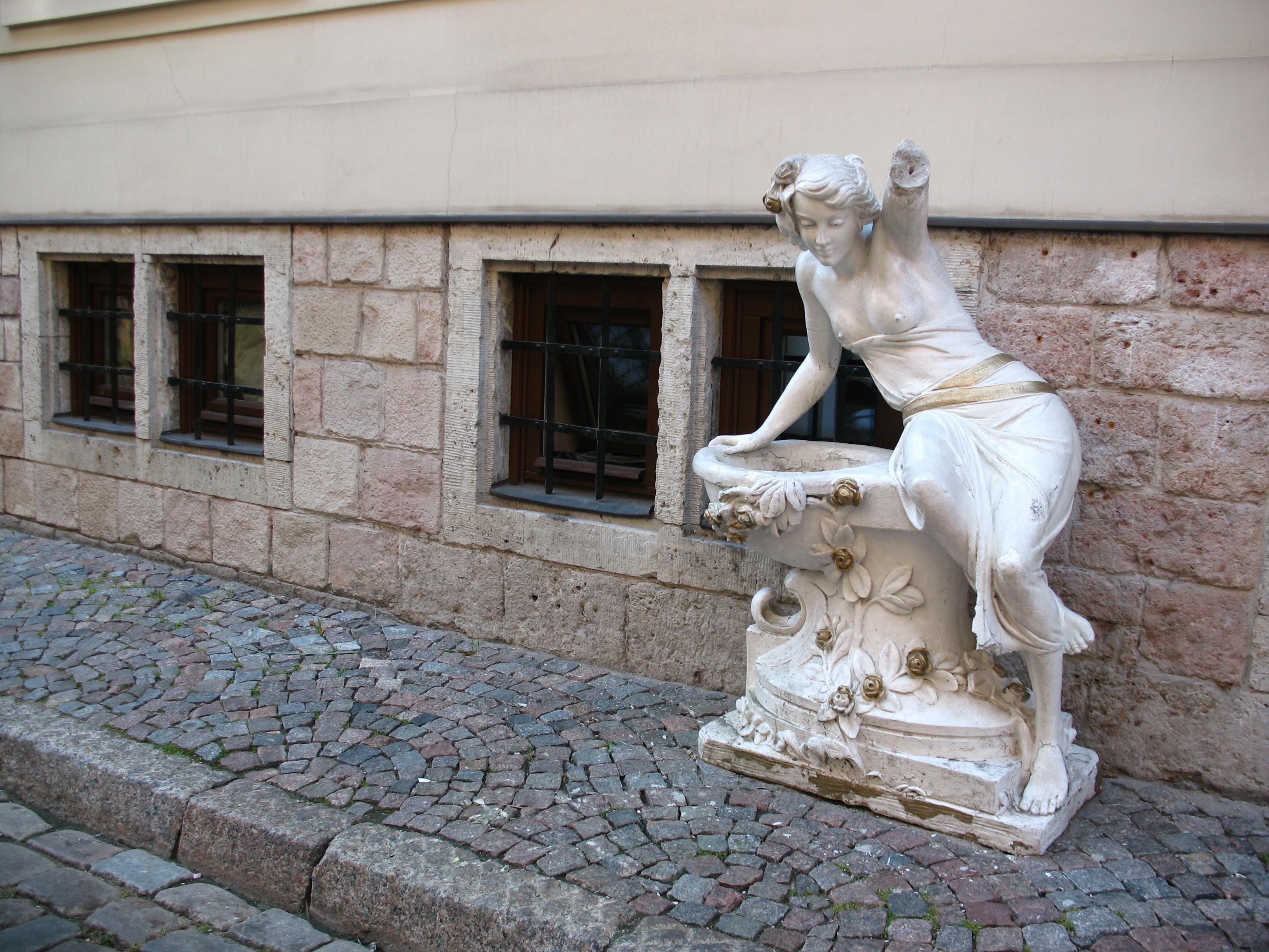 woman leaning on bird bath statue