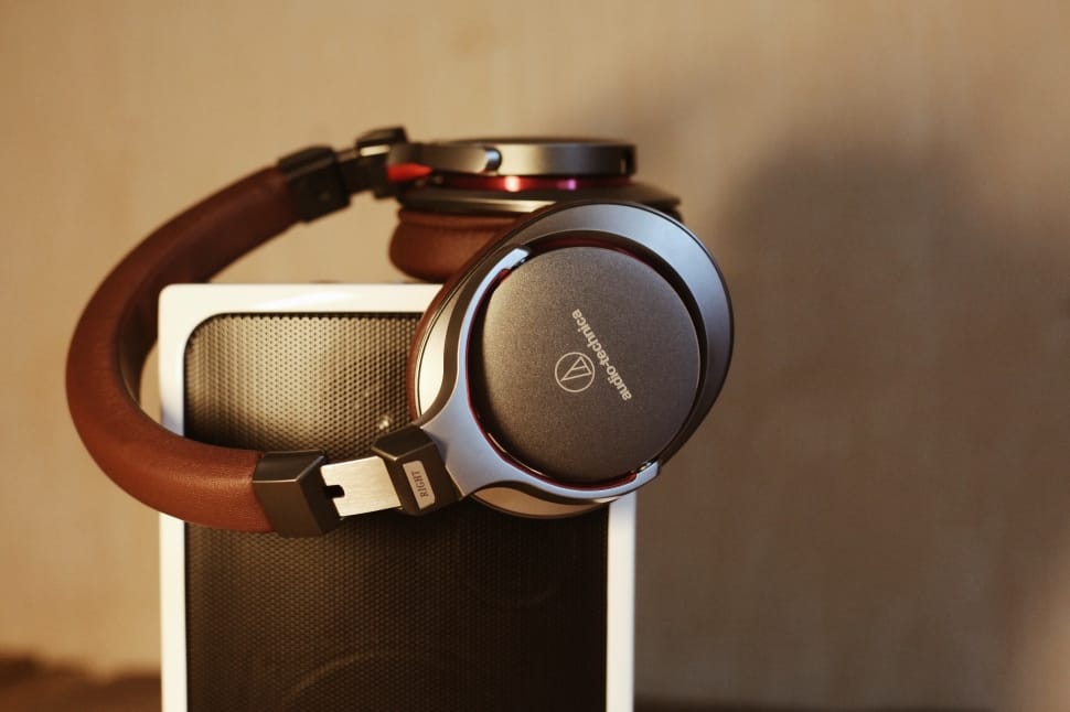 brown and gray wireless headphones on white speaker preview
