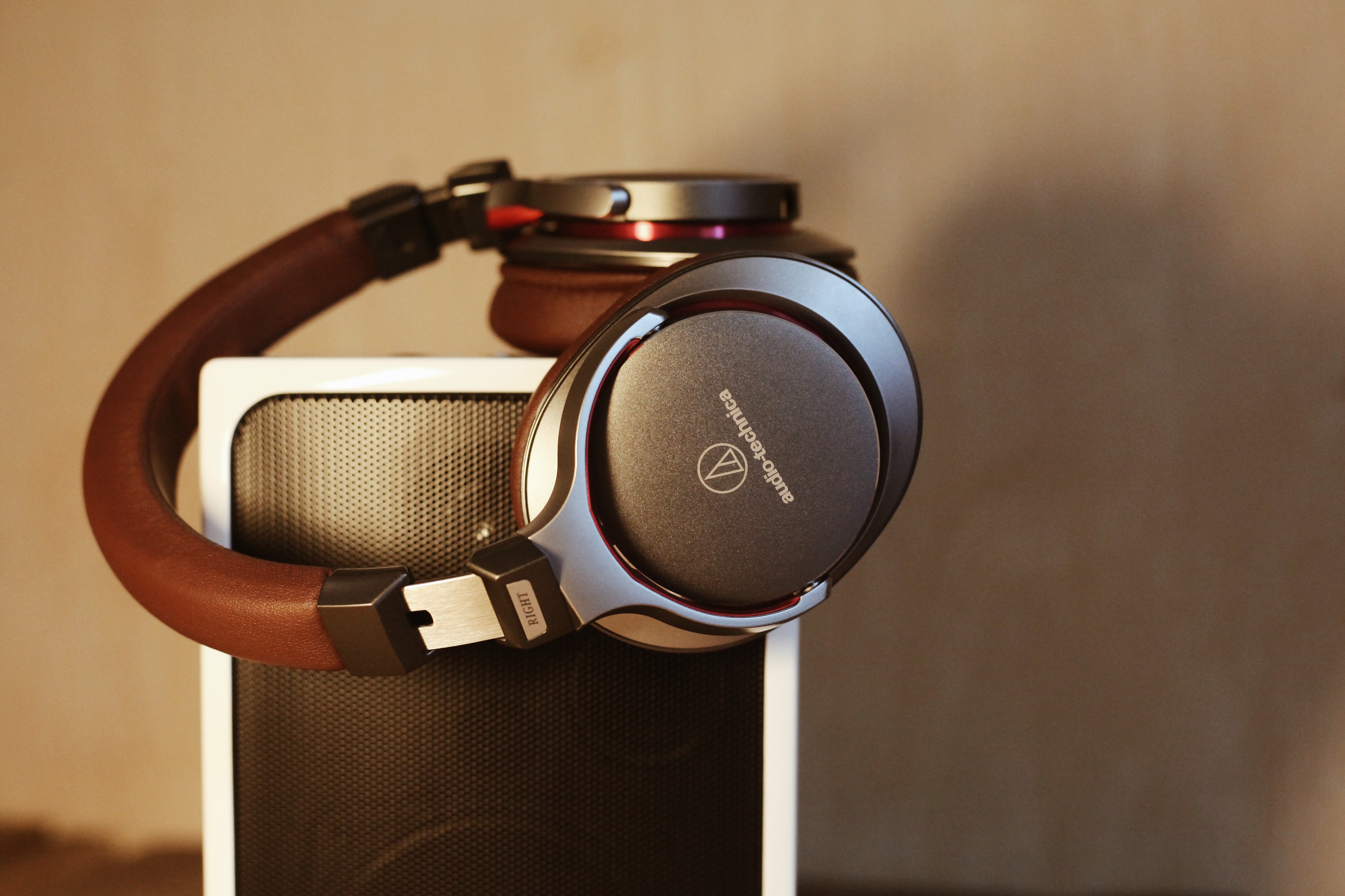 brown and gray wireless headphones on white speaker