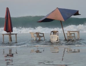 blue and red parasol and plastic chairs thumbnail