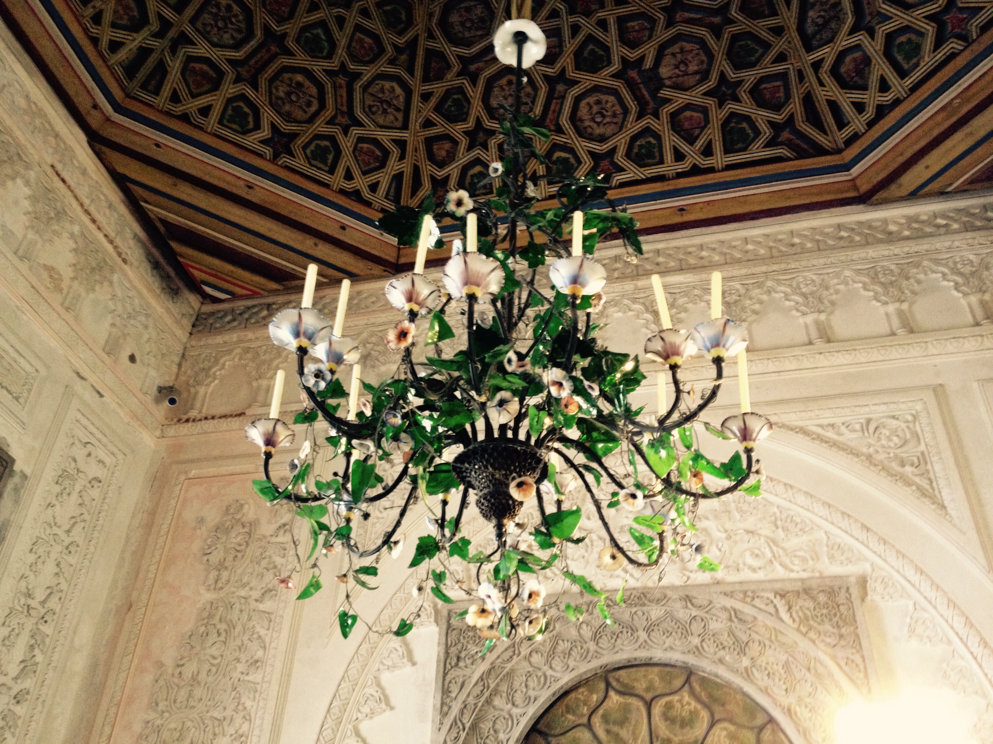 green and white candelabra chandelier with green plant
