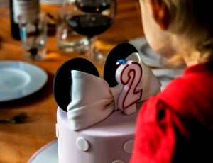 boy in red shirt near white and black cake thumbnail