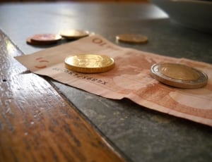 2 round coins on top of 10 banknote thumbnail