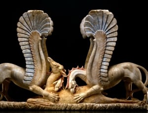 grey and brown ceramic dragon eating his prey  figurine thumbnail