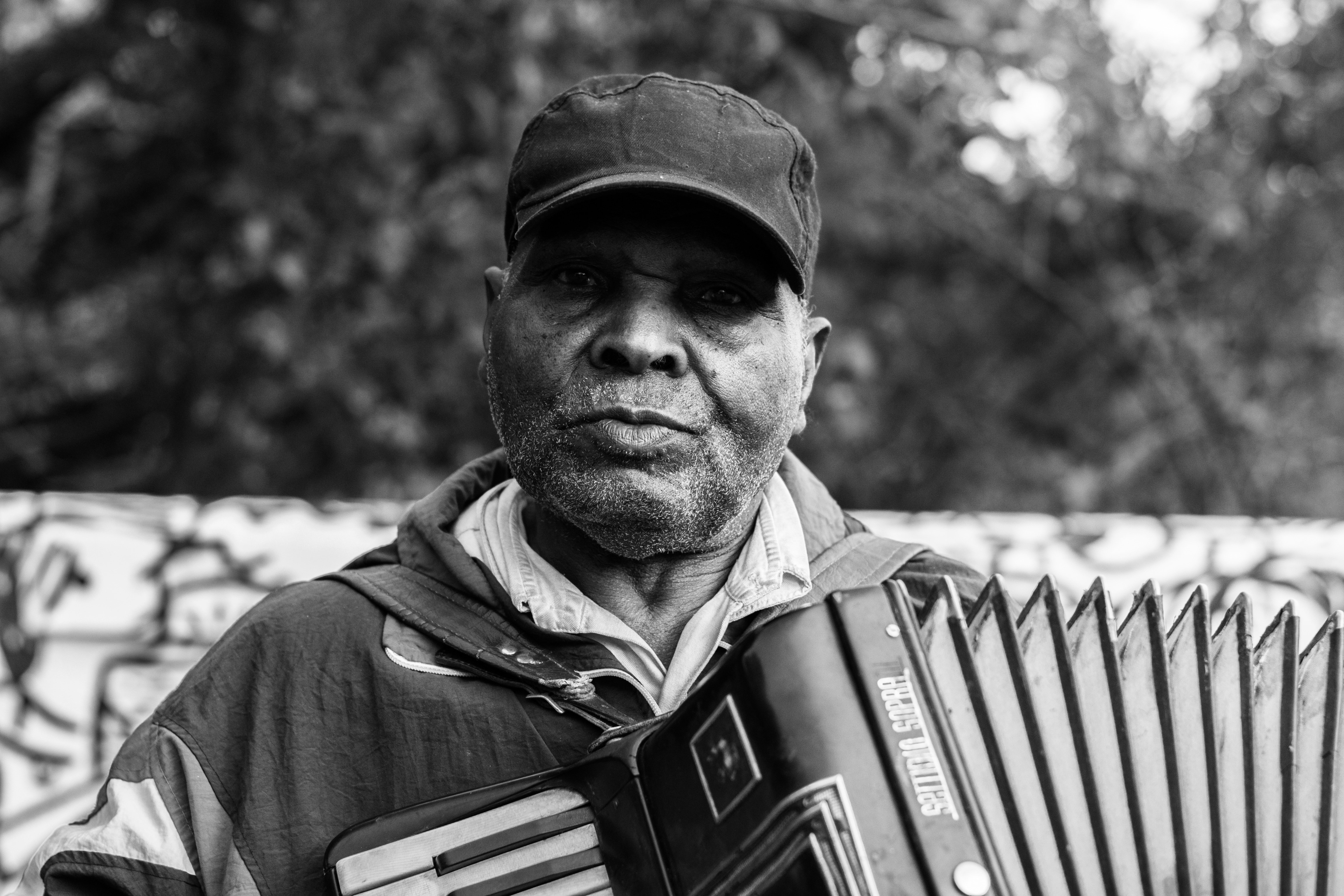 grayscale photography of a man playing accordion