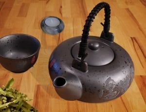 gray steel kettle beside gray steel cup on top of brown wooden surface thumbnail