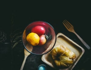 three fruits in clear glass bowl beside brown pastry on square brown wooden saucer thumbnail