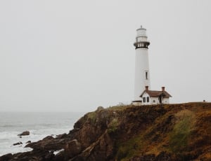 white lighthouse near sea shore thumbnail