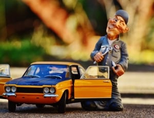 yellow and blue car scale model and man in grey suit figurine thumbnail