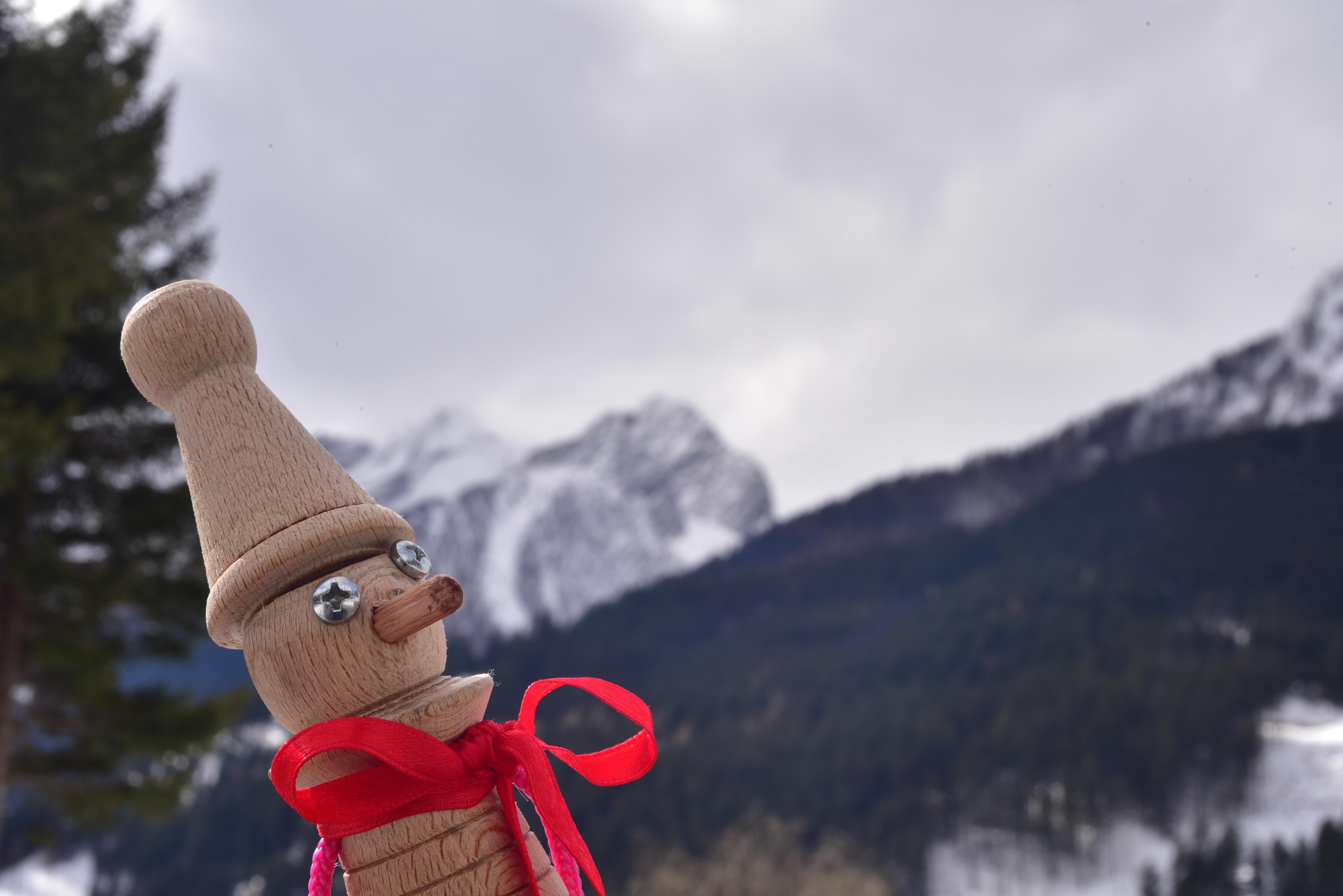 brown wooden character figurine with white snow cop in background