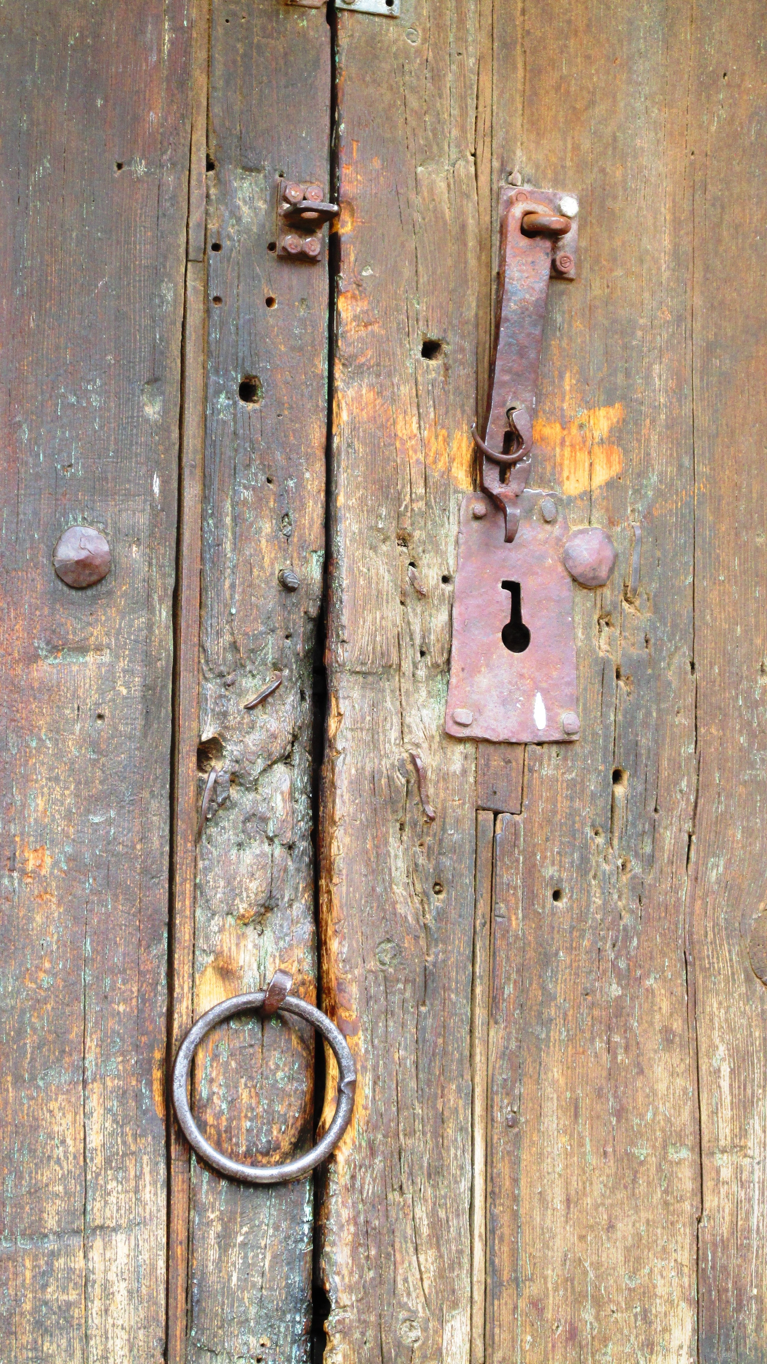 brown wooden door with metal padlock
